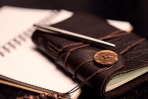 Journal and pen symbolizing how to write a will and answer estate planning questions